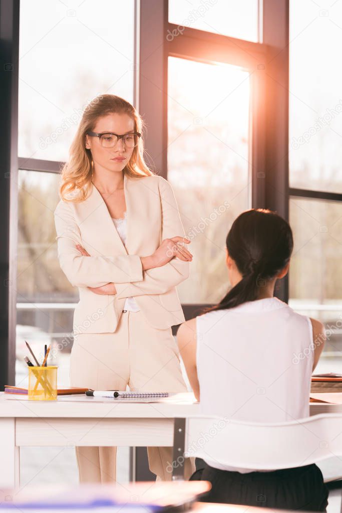 businesswomen in formalwear talking at office