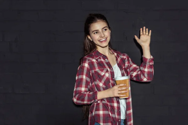 Chica con café agitando la mano — Foto de stock gratis