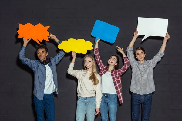 Teenagers holding blank speech bubbles — Stock Photo, Image