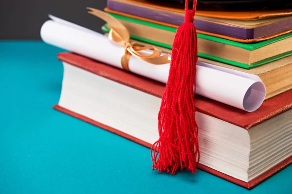 Libros, diploma y gorra de graduación - foto de stock