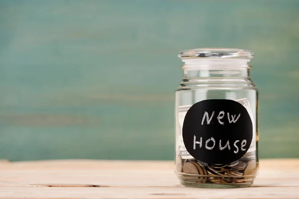 Coins in glass can with sign — Stock Photo