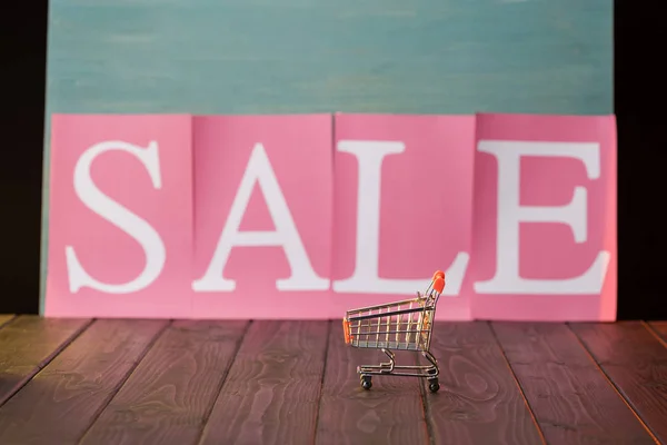 Small shopping cart with sale sign — Stock Photo