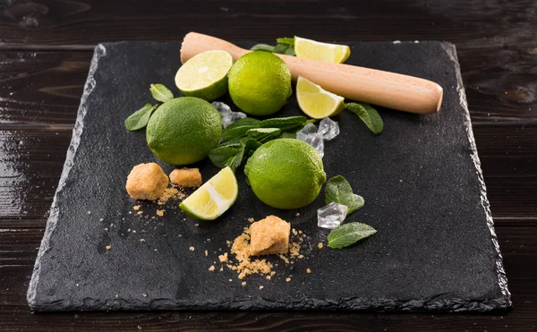 Limettenscheiben mit Zucker und Holzpresse — Stockfoto