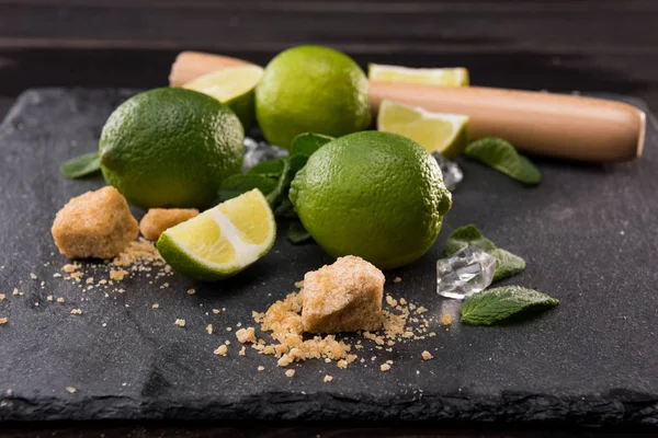 Limettenscheiben mit Zucker und Holzpresse — Stockfoto