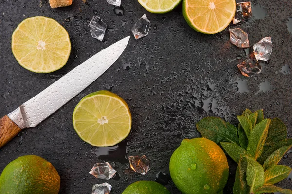 Ломтики лайма с листьями мяты и ножом — стоковое фото