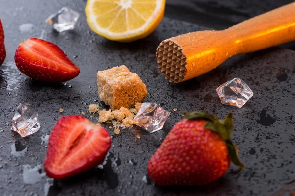 Wooden squeezer with lemon and strawberries — Stock Photo