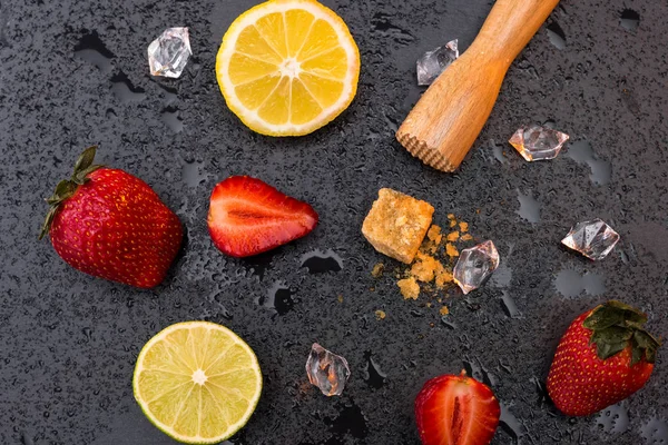 Wooden squeezer with lemon and strawberries — Stock Photo