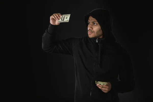 Ladrón afroamericano sosteniendo dinero - foto de stock