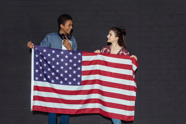 Pareja adolescente con bandera de EE.UU. - foto de stock