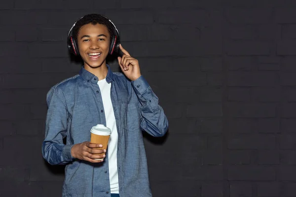 Adolescente chico con auriculares y café - foto de stock