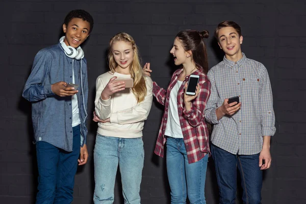 Stylish teenagers with smartphones — Stock Photo