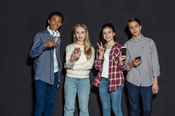 Stylish teenagers with smartphones — Stock Photo