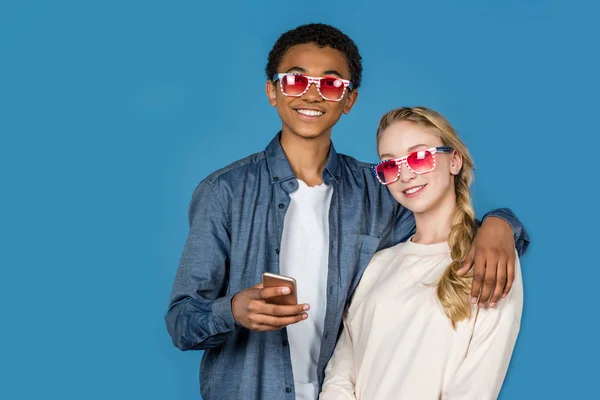 Adolescentes en gafas de color rosa con smartphone - foto de stock