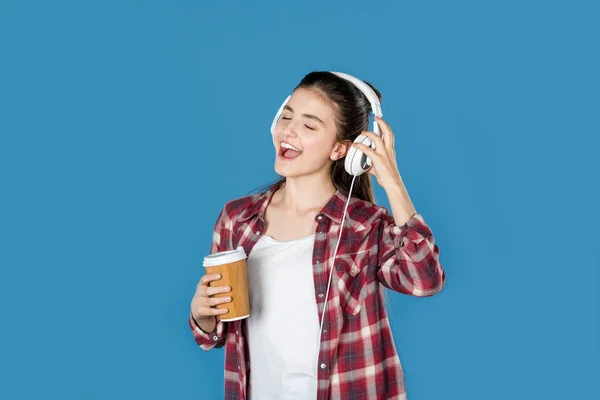 Chica escuchando música con café - foto de stock