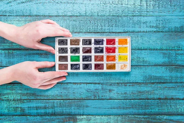 Hands holding paints — Stock Photo, Image