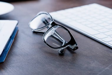 Eyeglasses on wooden table clipart