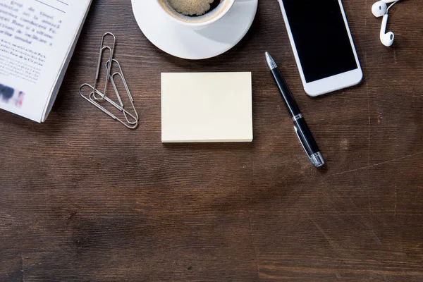 Kaffeetasse und Smartphone auf dem Schreibtisch — Stockfoto