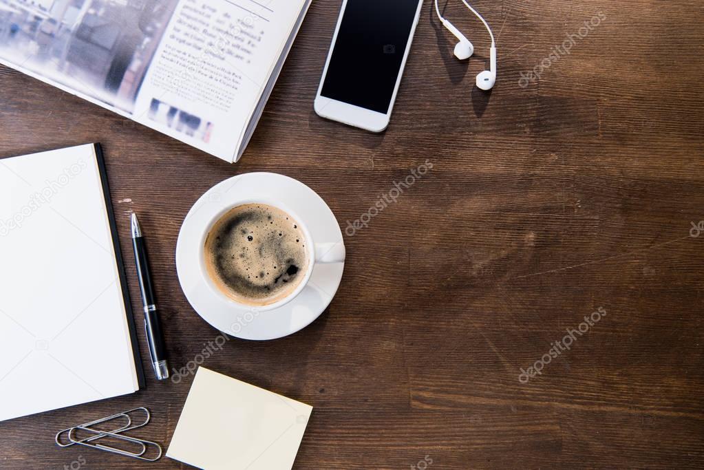 Coffee cup and smartphone on desk
