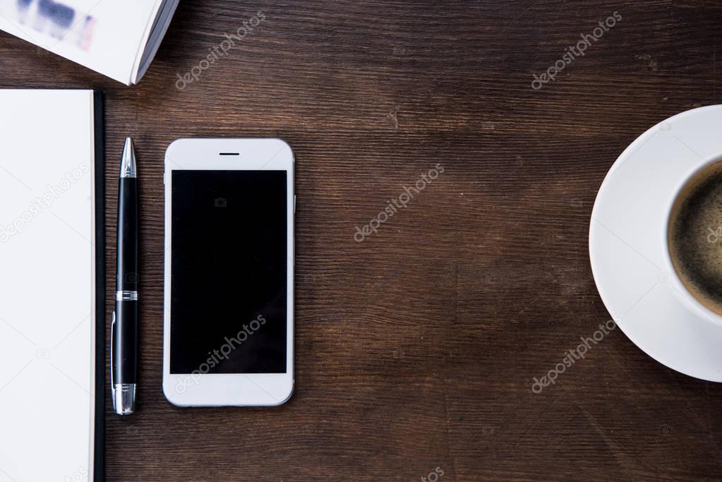 Coffee cup and smartphone on desk