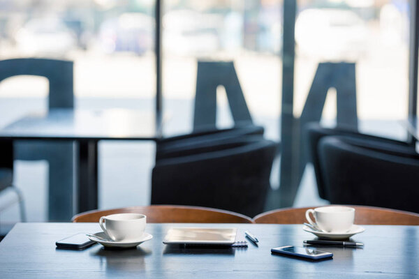 Кофейные чашки и устройства на столе
 