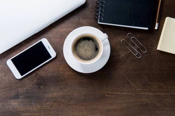 Taza de café y smartphone en el escritorio - foto de stock