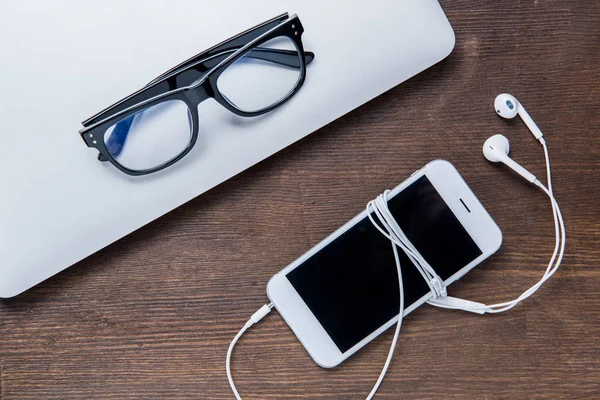 Smartphone y portátil con gafas - foto de stock