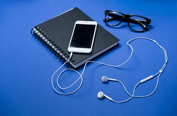 Smartphone and notebook on table — Stock Photo