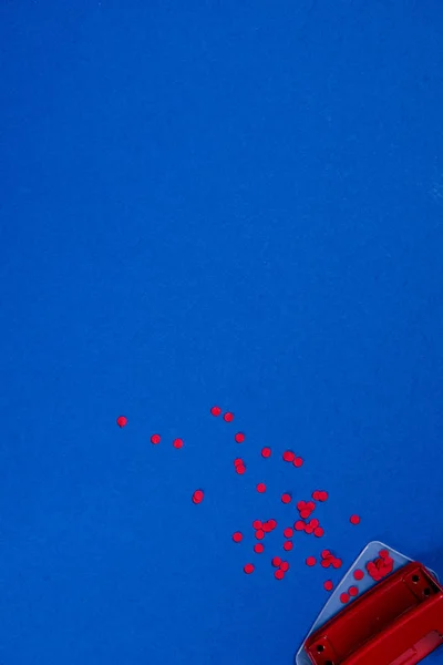 Perforador con piezas de papel rojo - foto de stock