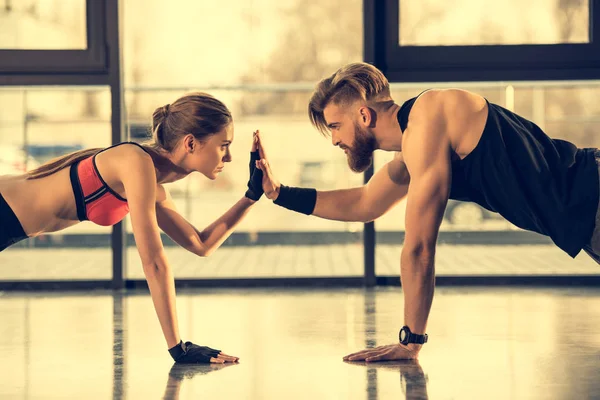Homem e mulher fazendo exercício de prancha — Fotografia de Stock