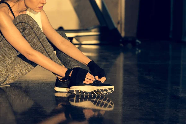 Tired sportswoman sitting on floor — Stock Photo