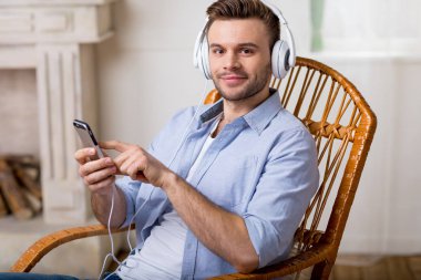 man in headphones using smartphone