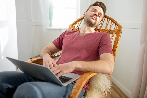 Homme avec ordinateur portable dans une chaise berçante — Photo