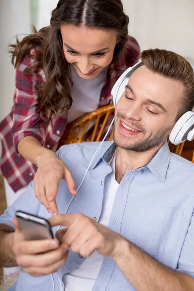 Homme dans les écouteurs en utilisant un smartphone — Photo