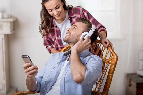 Homem em fones de ouvido usando smartphone — Fotografia de Stock