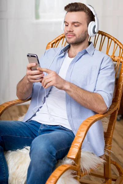 Mann mit Kopfhörer benutzt Smartphone — Stockfoto