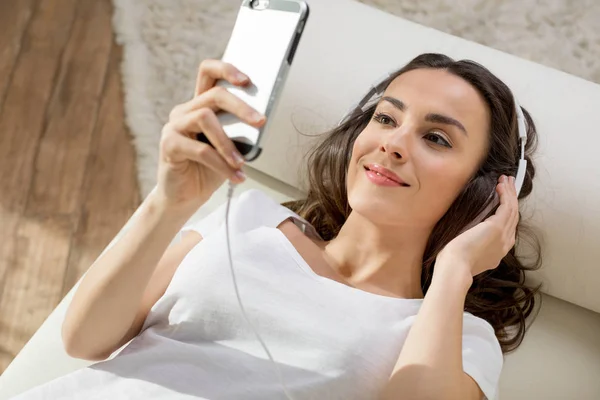 Woman in headphones using smartphone Stock Image