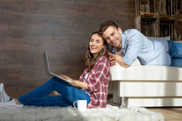 Unga par som använder bärbar dator Stockbild