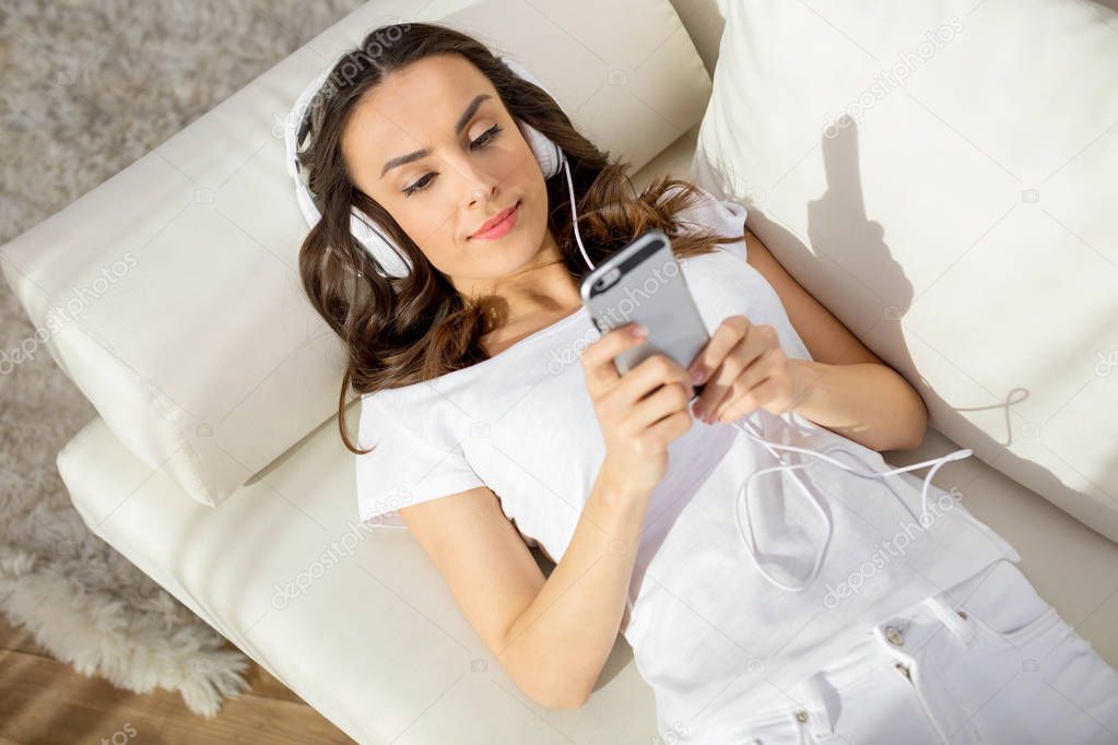 Woman in headphones using smartphone 