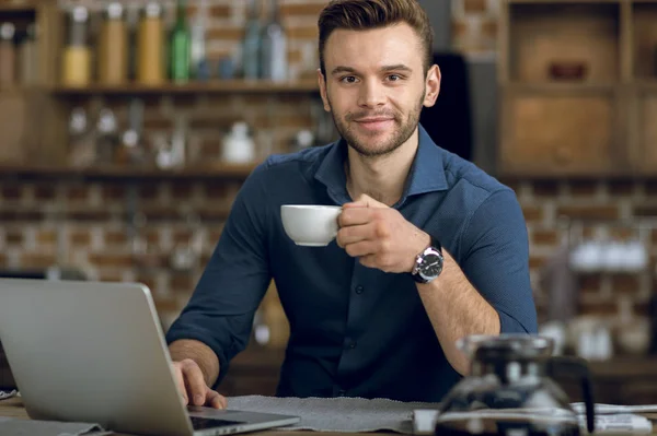 Hombre beber café y el uso de ordenador portátil — Foto de Stock