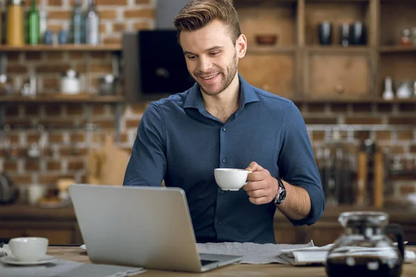 Hombre beber café y el uso de ordenador portátil —  Fotos de Stock