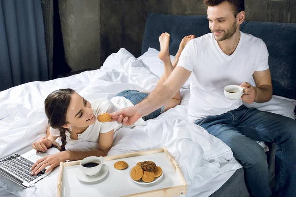 Woman using laptop in bed Stock Image