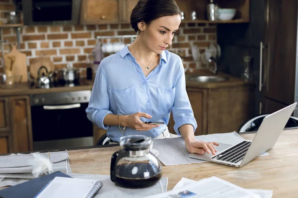 Mujer usando laptop y smartphone - foto de stock