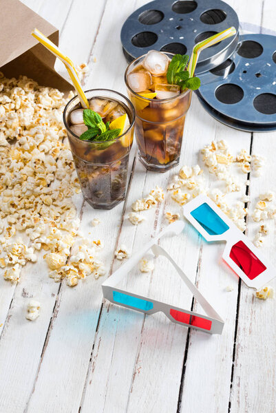 Popcorn with iced tea and film reels   