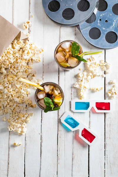 Popcorn with iced tea and film reels — Stock Photo, Image