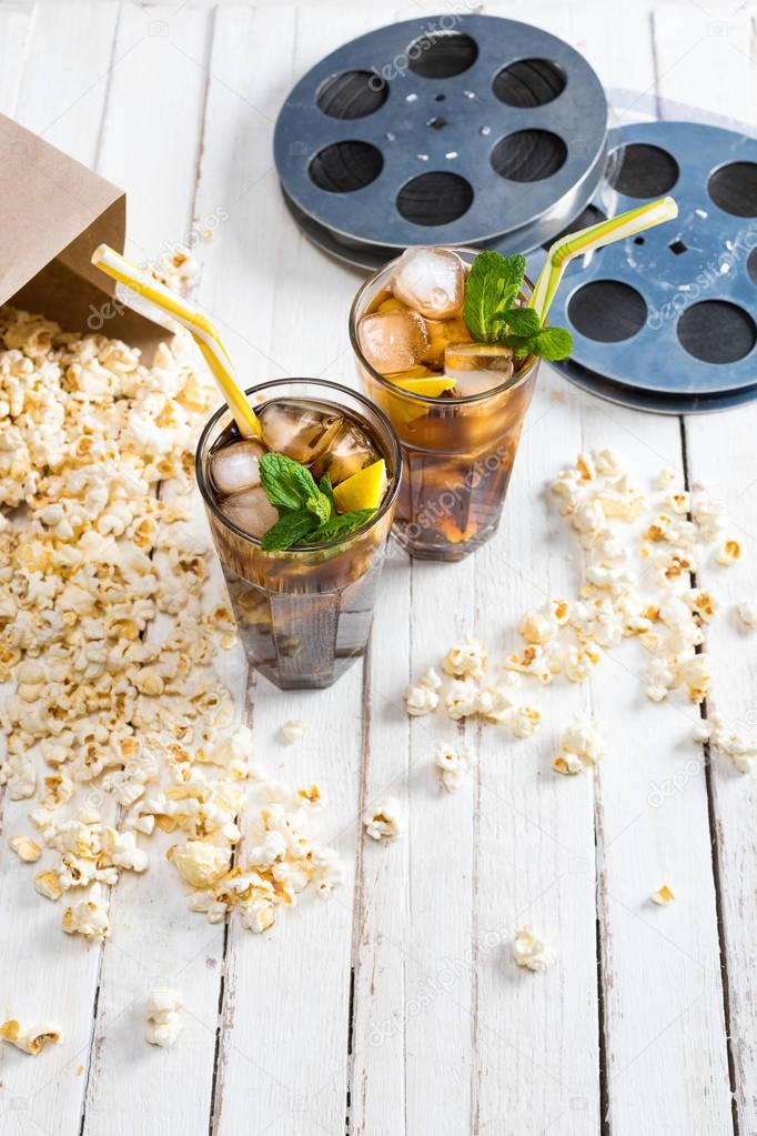Popcorn with iced tea and film reels 