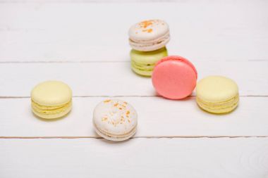 Group of macarons on wooden table clipart