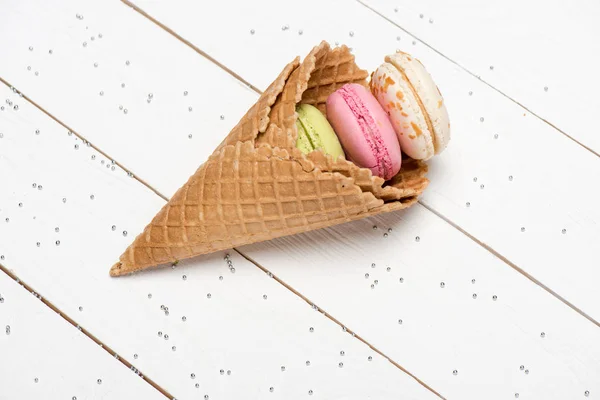 Colorful macarons in waffle cones — Stock Photo, Image