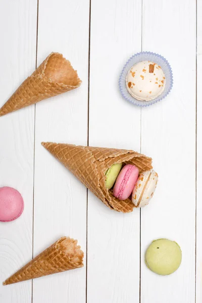 Waffle cones with colorful macarons — Stock Photo, Image