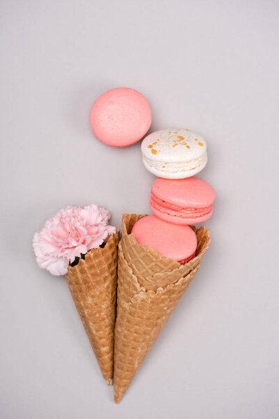 Group of pink macarons with waffle cones