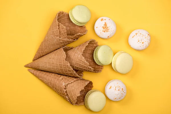 Yellow and white macarons in waffle cones — Stock Photo, Image